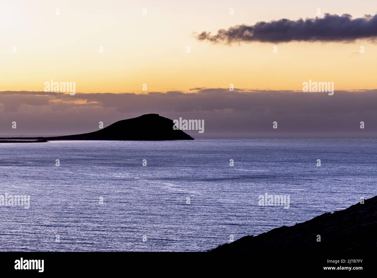 Montaña roja, Montaña Roja en silueta al amanecer. Amanecer en la costa este de Tenerife, Islas Canarias, España Foto de stock