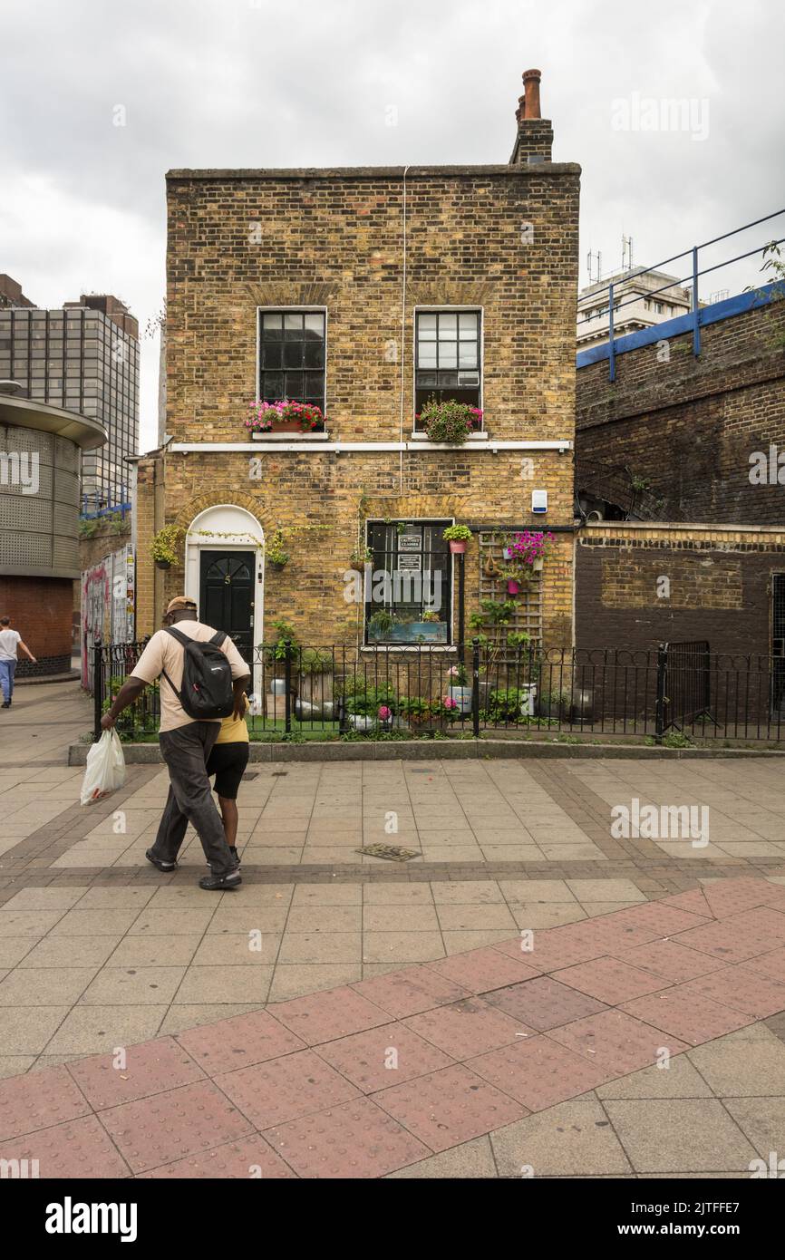 Un padre y un niño caminando por una solitaria casa adosada a la izquierda en las afueras de Waterloo Station, Southbank, Londres, SE1, Inglaterra, REINO UNIDO Foto de stock
