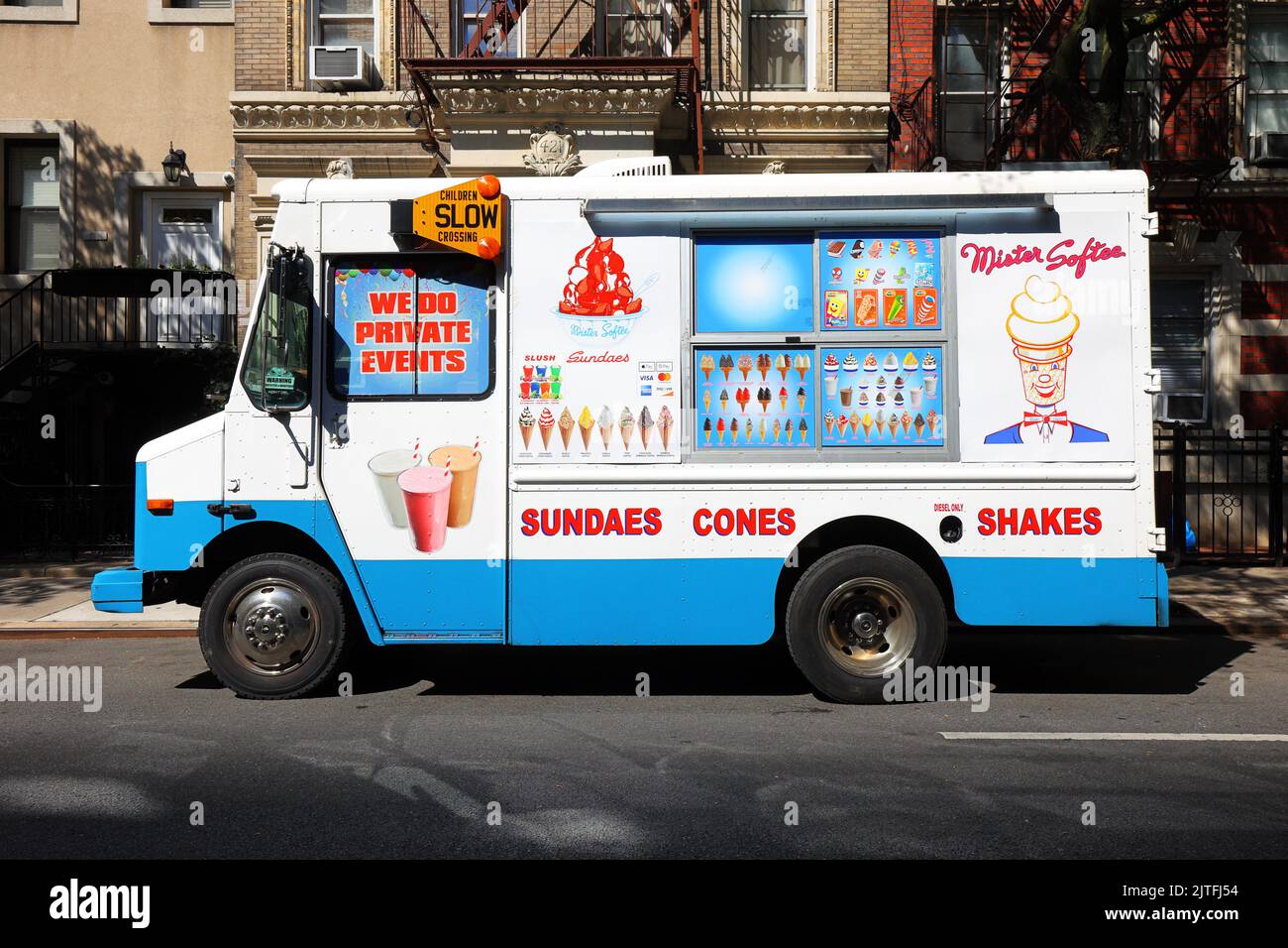 Un camión de helados blandos Mister Softee estacionado en una calle de Nueva York bajo la luz del sol. Foto de stock