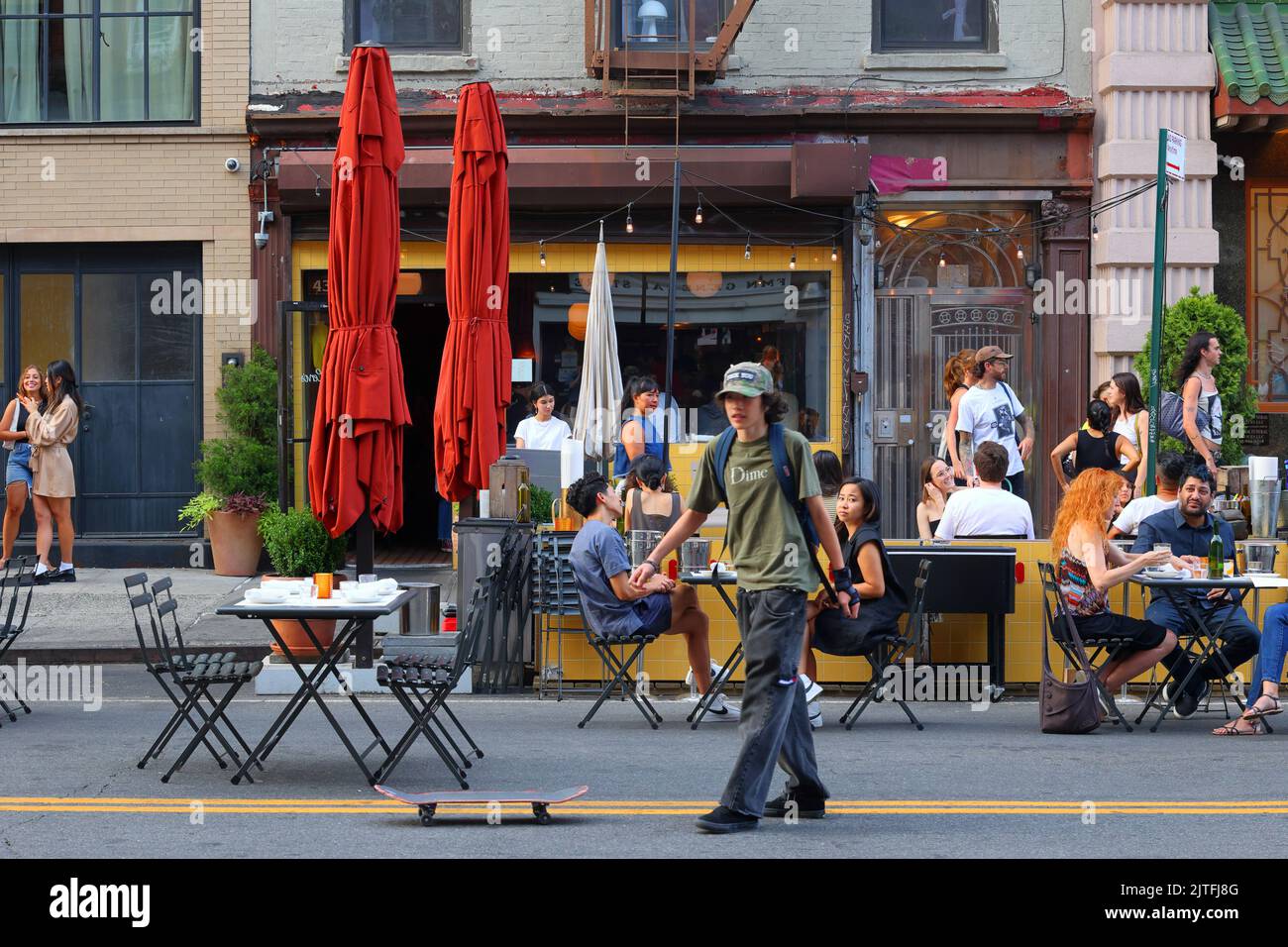 Skateboarder y cenas fuera de Cervo's, 43 Canal St, en Manhattan 'Dimes Square' Chinatown/Lower East Side, Nueva York. Foto de stock