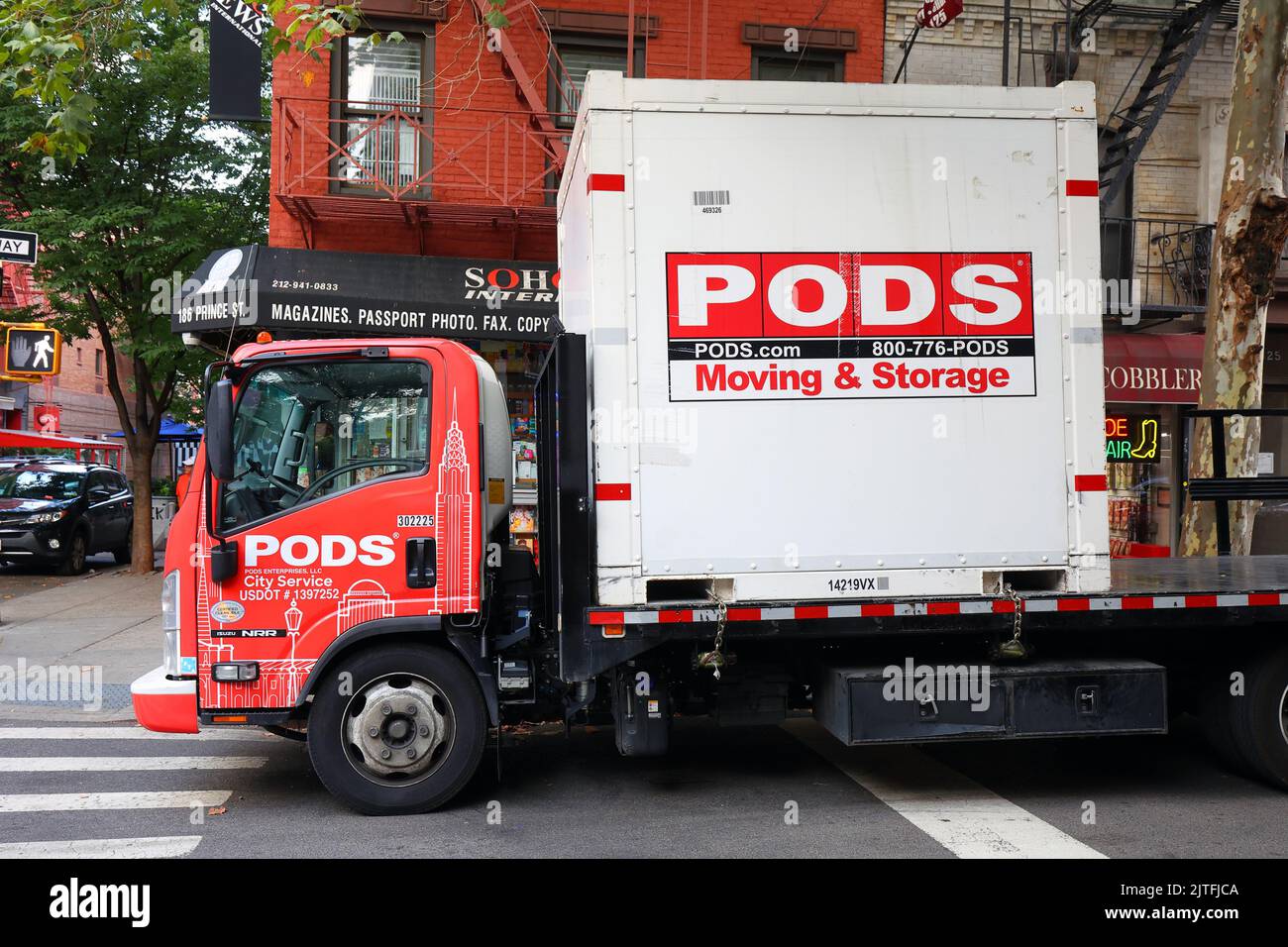 Un contenedor de almacenamiento portátil bajo demanda PODS City Service de 8 pies en un camión de plataforma plana. PODS es propiedad del Ontario Teachers' Pension Plan Foto de stock