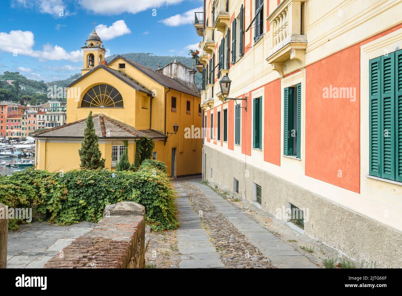 Calle estrecha entre coloridos edificios en el puerto de Santa Margherita, Ligure, Italia. Foto de stock