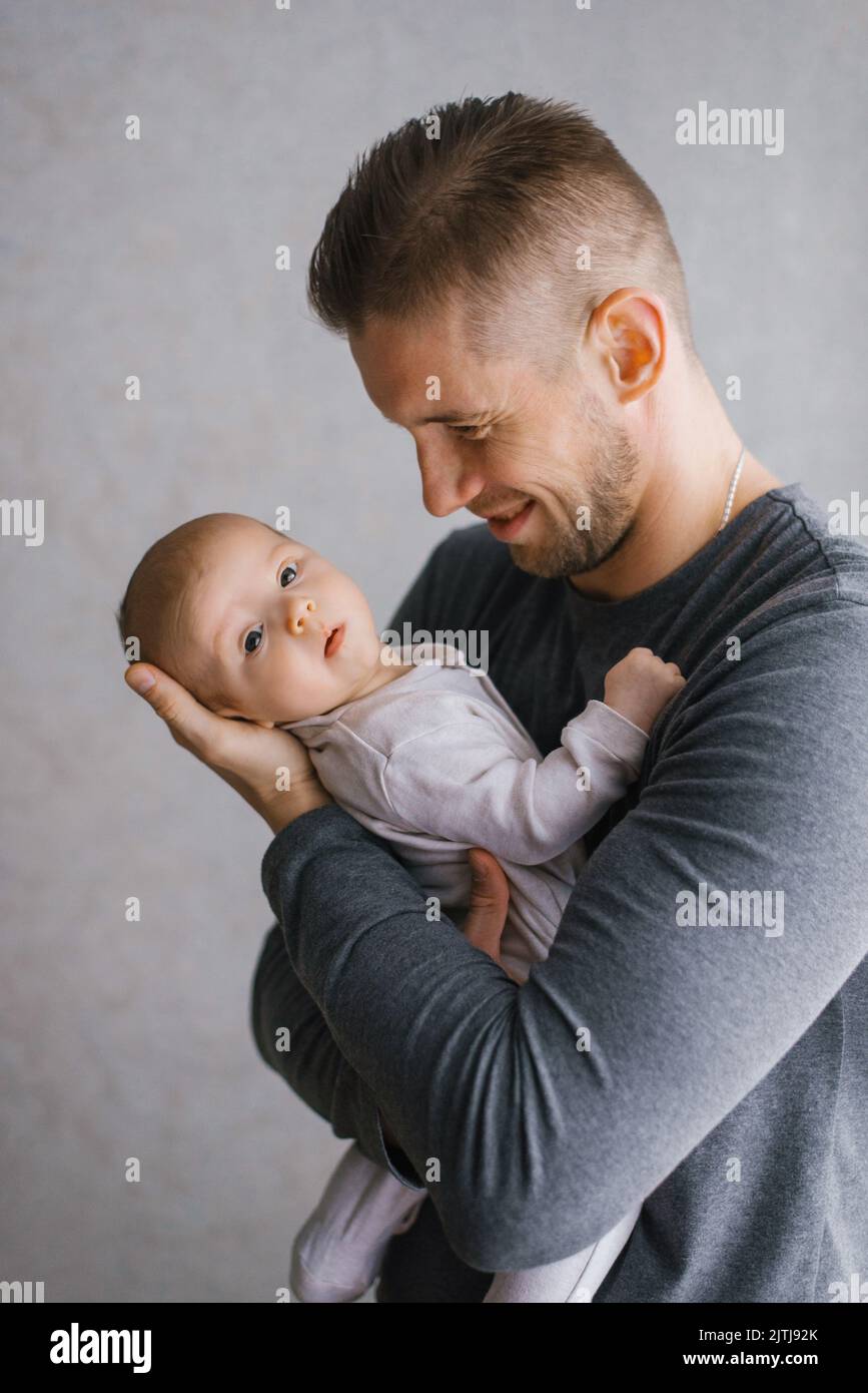 Papá sosteniendo a su hijo en sus brazos en casa Foto de stock
