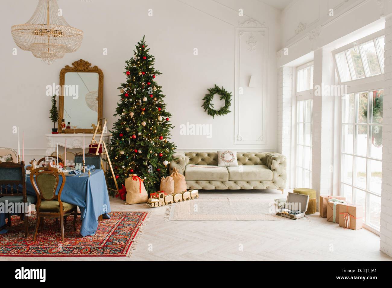 El interior clásico de Navidad de Año Nuevo de la habitación está decorado con un árbol de Navidad. Árbol de Navidad con adornos dorados y rojos y cajas de regalo. Chris Foto de stock
