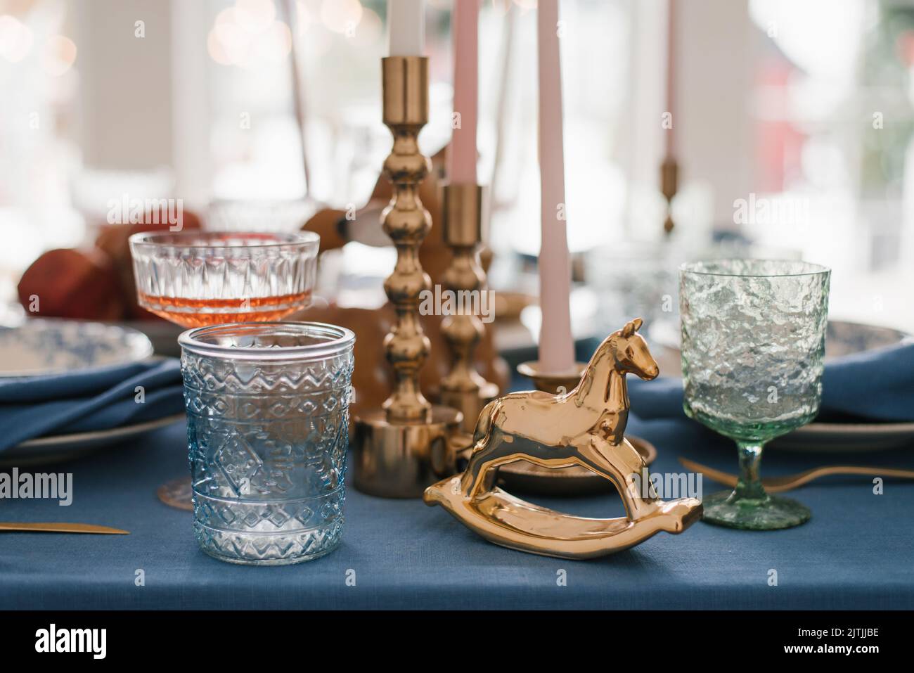 Caballo de época, vasos de cristal y candelabros en el marco festivo de la mesa de Navidad Foto de stock