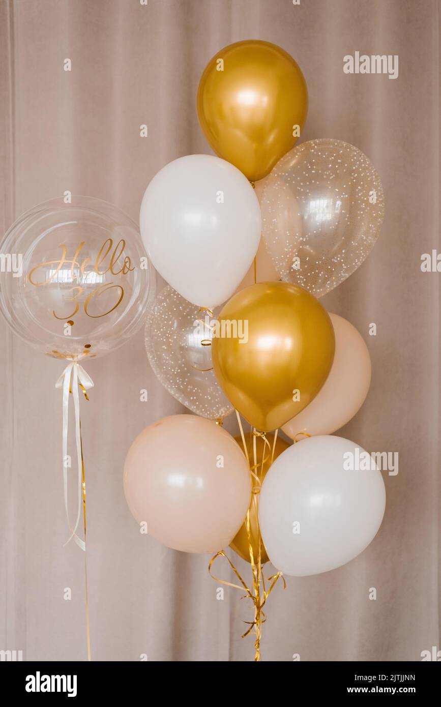 Decoración para la celebración del 30th aniversario. Globos de helio en colores oro, rosa y blanco Foto de stock