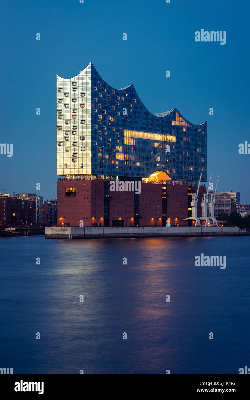 La Filarmónica del Elba y HafenCity en el puerto de Hamburgo al anochecer, Alemania Foto de stock