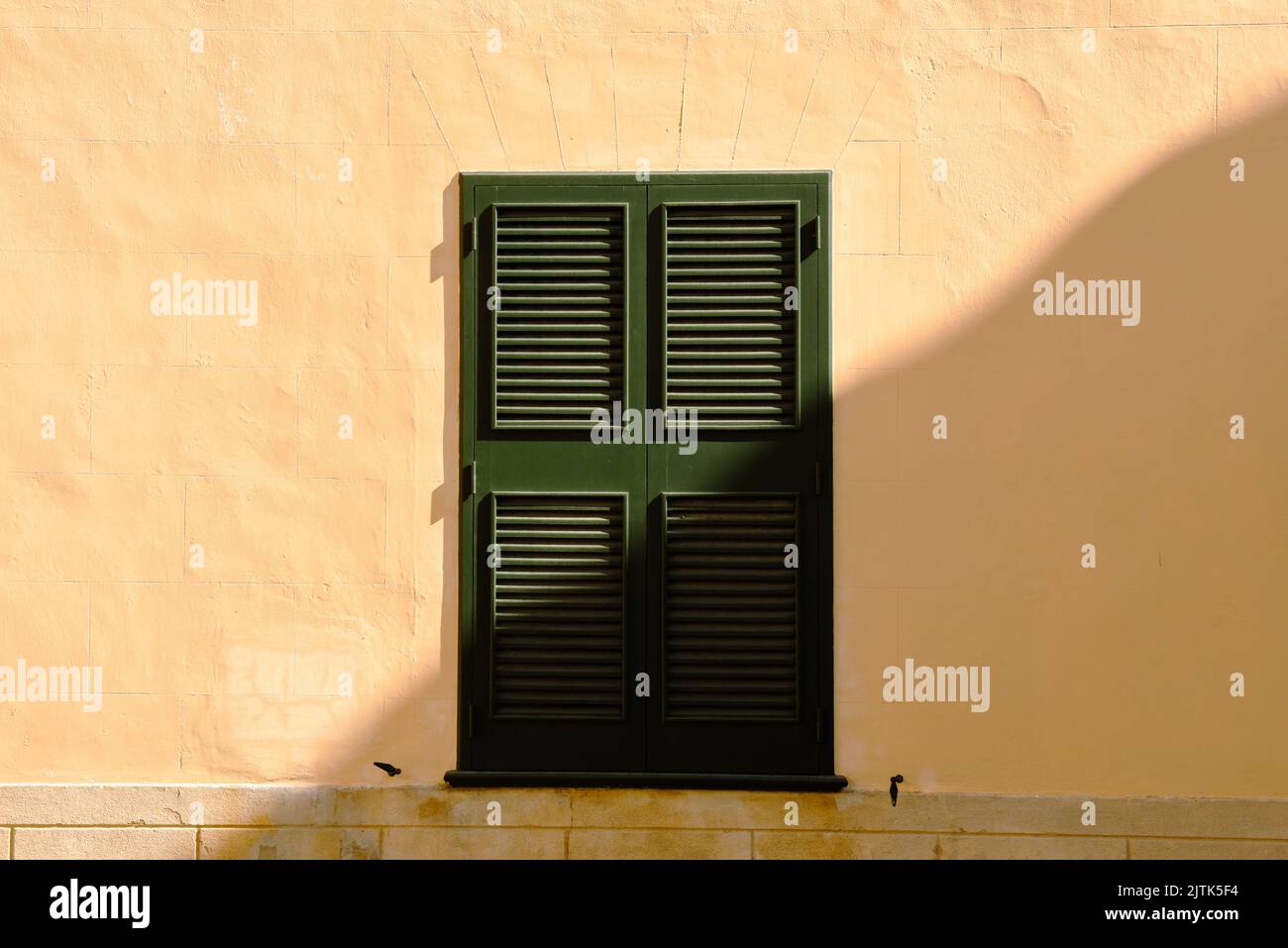 Tradicional ventana española con persianas a la luz del sol de la mañana Foto de stock