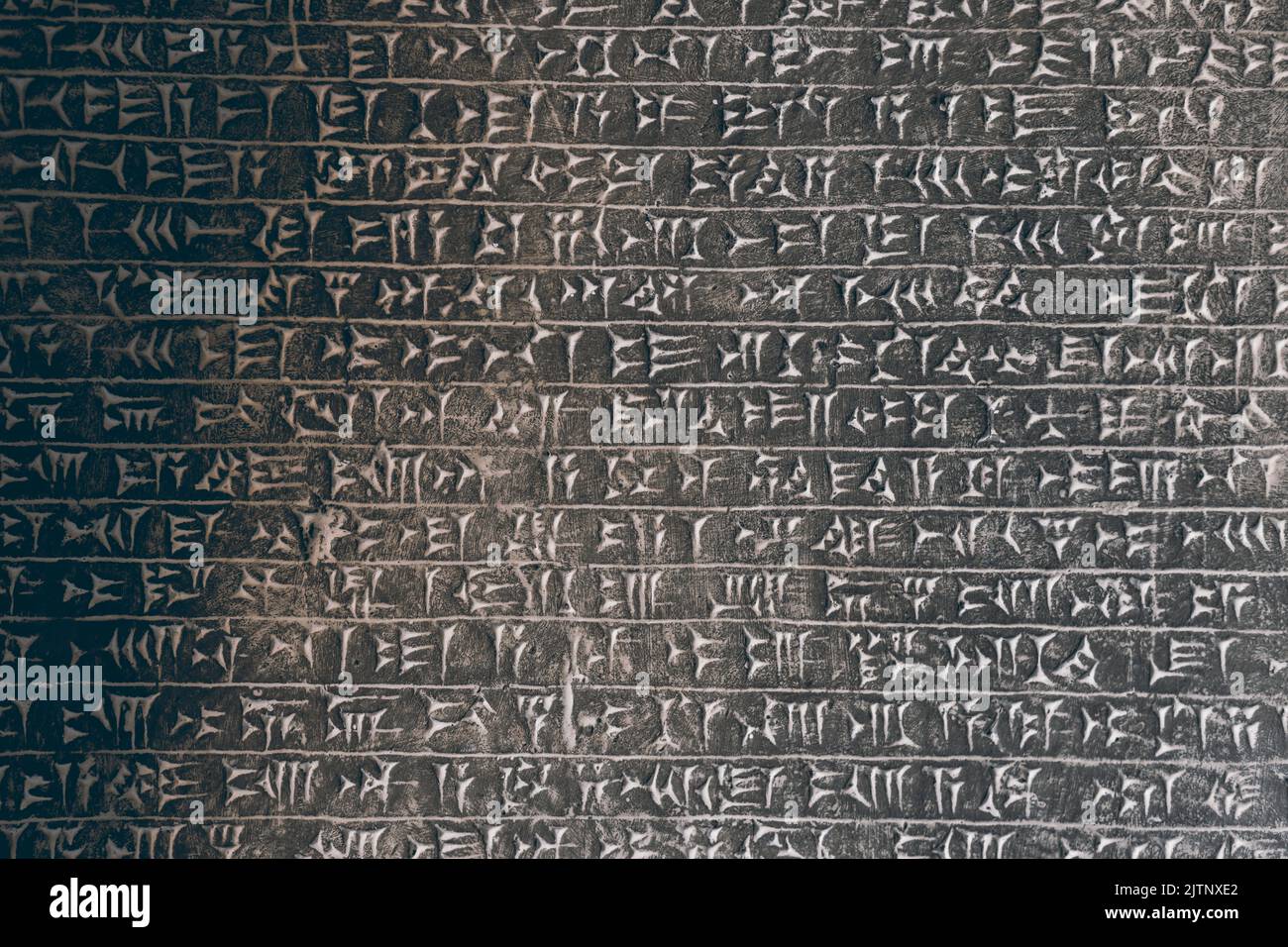 Fondo histórico de gran pared de piedra cubierta por la antigua Asiria cuneiforme Foto de stock