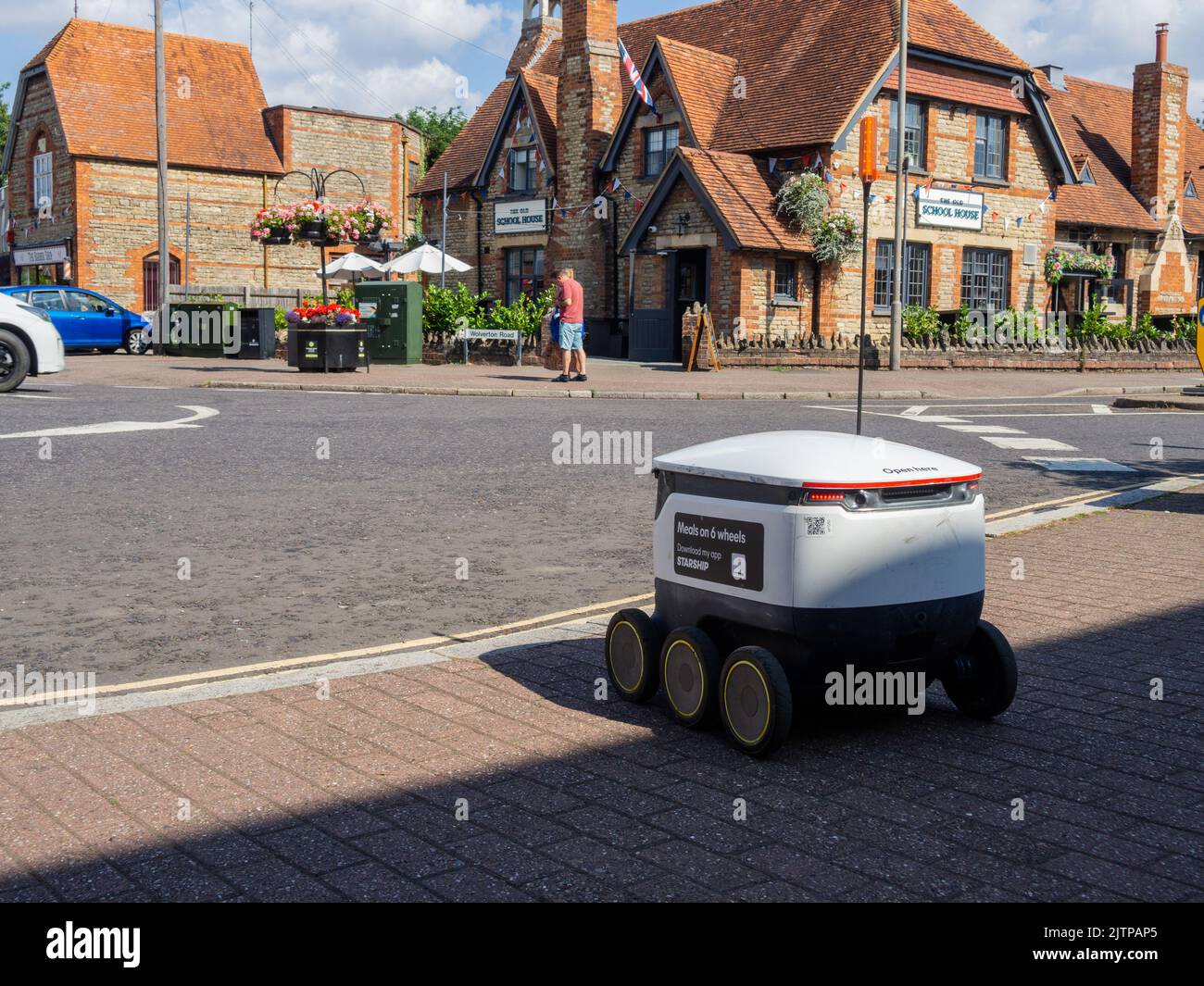 Un robot de entrega de alimentos sin conductor, de Starship Technologies, espera cruzar la carretera en Stony Stratford, Buckinghamshire, Reino Unido Foto de stock