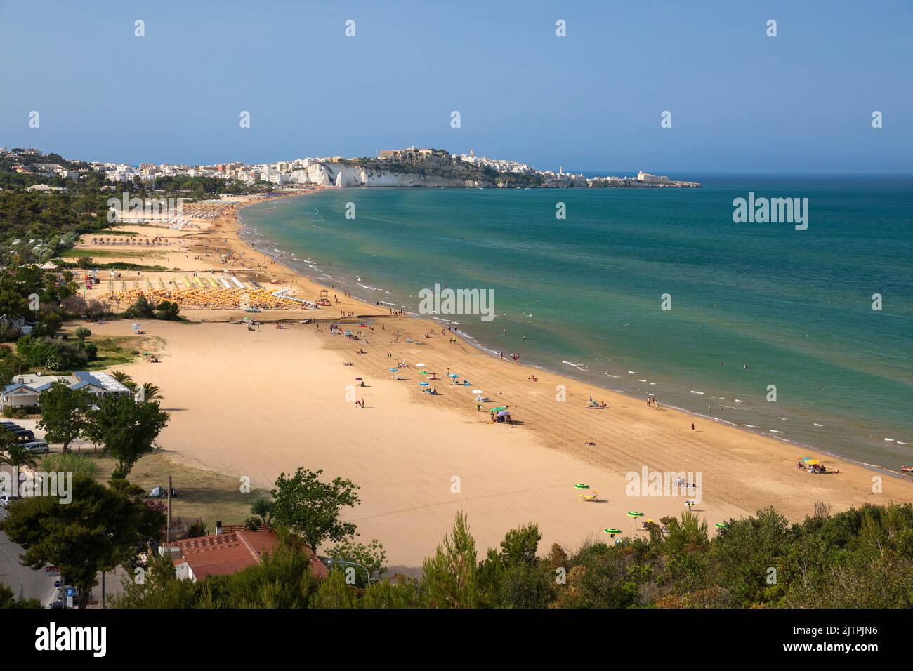 Vista a lo largo de la playa con el casco antiguo de Vieste en la distancia, Vieste, Apulia, Italia Foto de stock