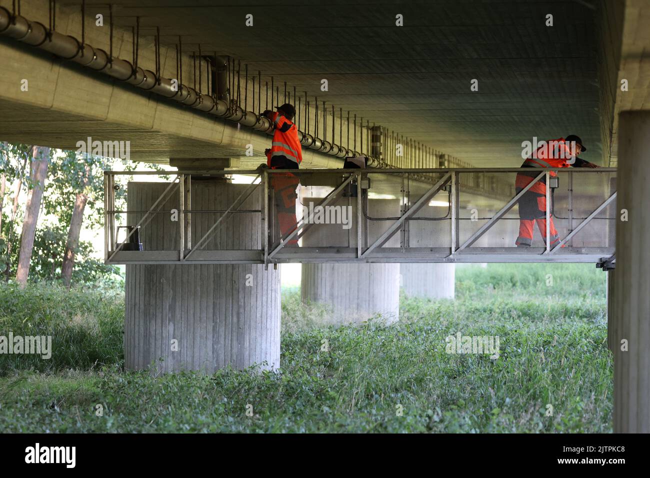 Gadebusch, Alemania. 01st de Sep de 2022. Stefan Ziegenhals (l-r) y Gunnar Wigger, de la Dirección de Construcción de Carreteras, someten el puente de la B108 sobre el Radegast a una inspección. Están parados sobre un brazo de doce metros fijado a un vehículo especial en el puente. Desde el 29 de julio de 2022, se han inspeccionado 16 puentes de carretera en el norte y el oeste de Mecklenburg para garantizar la estabilidad. La inspección principal regular es obligatoria para todos los puentes cada seis años. Crédito: Bernd Wüstneck/dpa/ZB/dpa/Alamy Live News Foto de stock