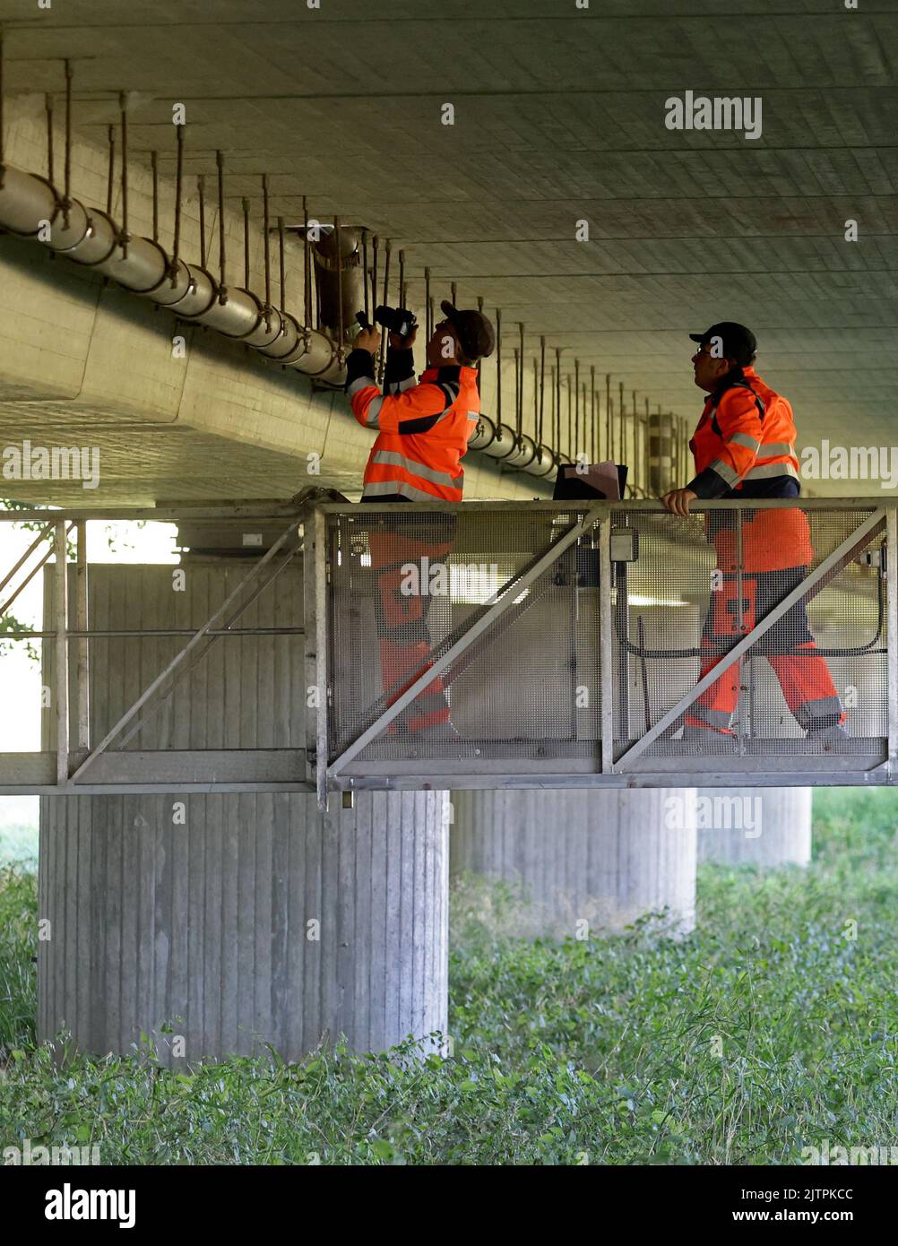 Gadebusch, Alemania. 01st de Sep de 2022. Stefan Ziegenhals (l-r) y Gunnar Wigger, de la Dirección de Construcción de Carreteras, someten el puente de la B108 sobre el Radegast a una inspección. Están parados sobre un brazo de doce metros fijado a un vehículo especial en el puente. Desde el 29 de julio de 2022, se han inspeccionado 16 puentes de carretera en el norte y el oeste de Mecklenburg para garantizar la estabilidad. La inspección principal regular es obligatoria para todos los puentes cada seis años. Crédito: Bernd Wüstneck/dpa/ZB/dpa/Alamy Live News Foto de stock