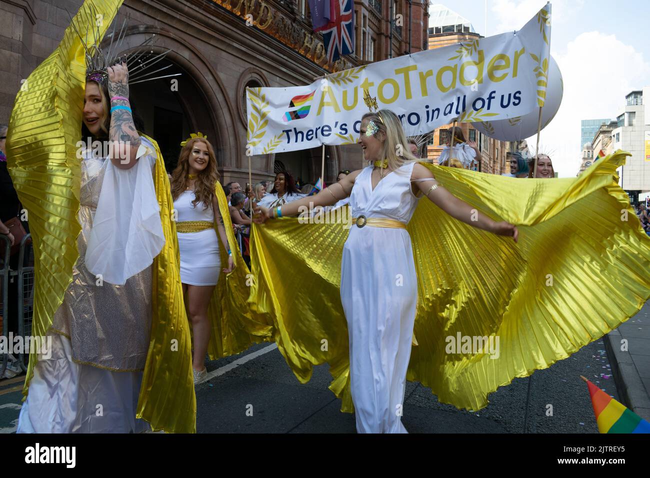 Desfile del Orgullo de Manchester. Desfile de AutoTrader frente al Hotel Midland. Mujer con traje de oro y blanco. Marcha temática por la paz Foto de stock