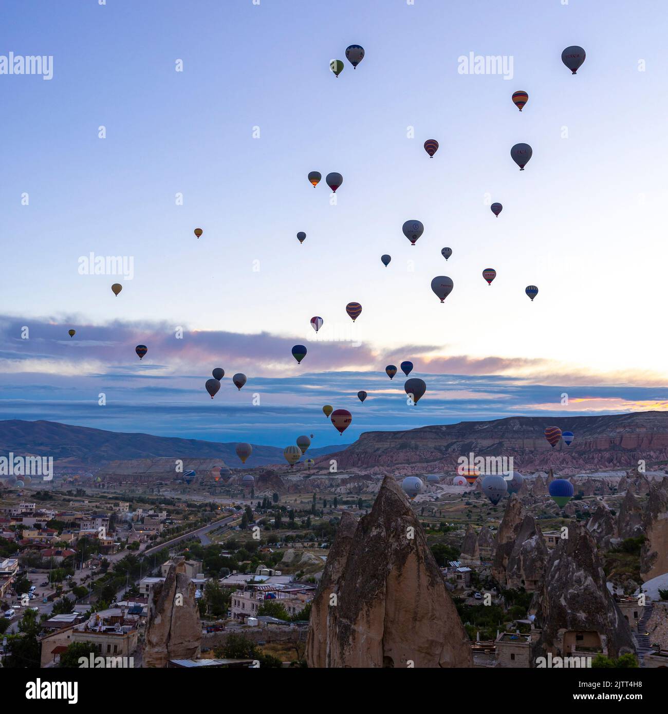 GOREME/TURQUÍA - 27 de junio de 2022: Varios globos de aire caliente vuelan al amanecer en el cielo de goreme Foto de stock
