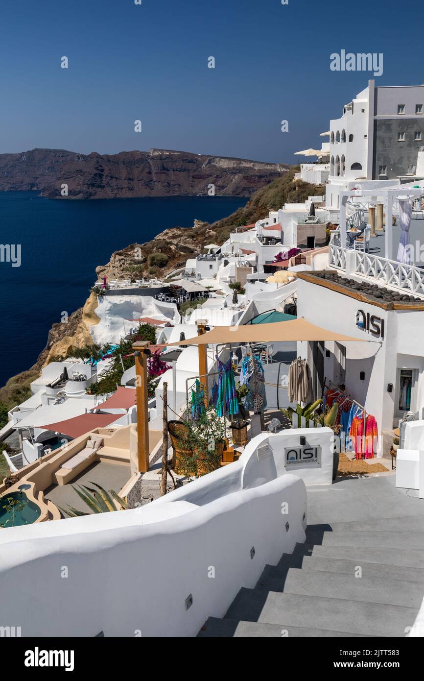 Pintorescos edificios encalados y vestidores Nisi situados en la caldera con vistas al mar Egeo, Oia, Santorini, Grecia y Europa Foto de stock