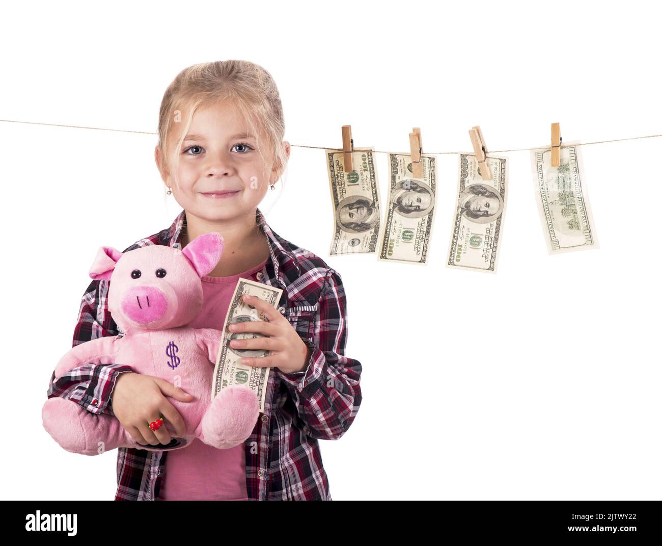 los niños y el dinero. Chica con un banco de cerdos. Chica colgando billetes de dólar en una cuerda aislada sobre fondo blanco Foto de stock
