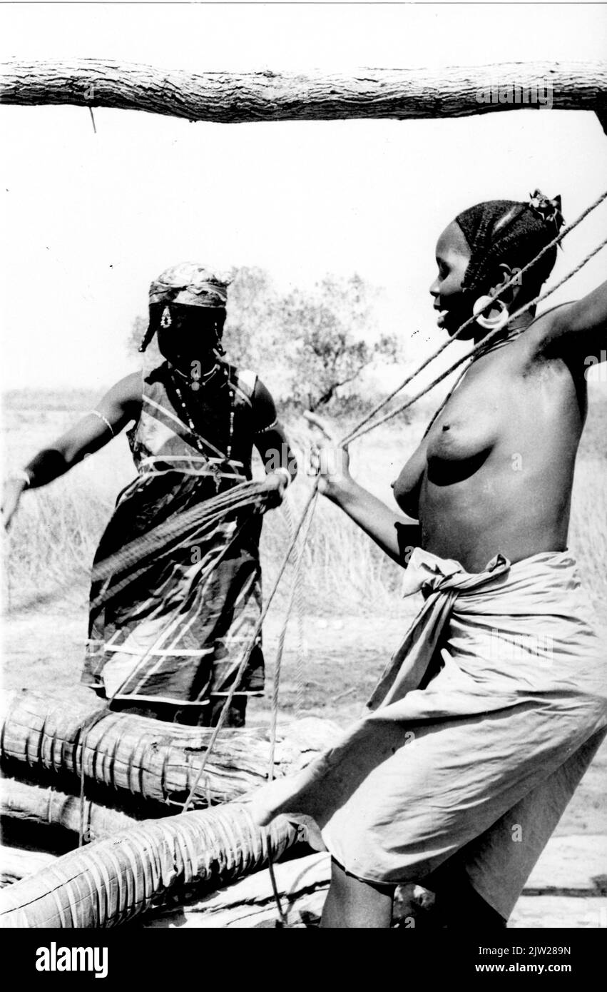 Mujeres de Fula sacando agua de pozo Alta Gambia Oeste de África 1967 Foto de stock