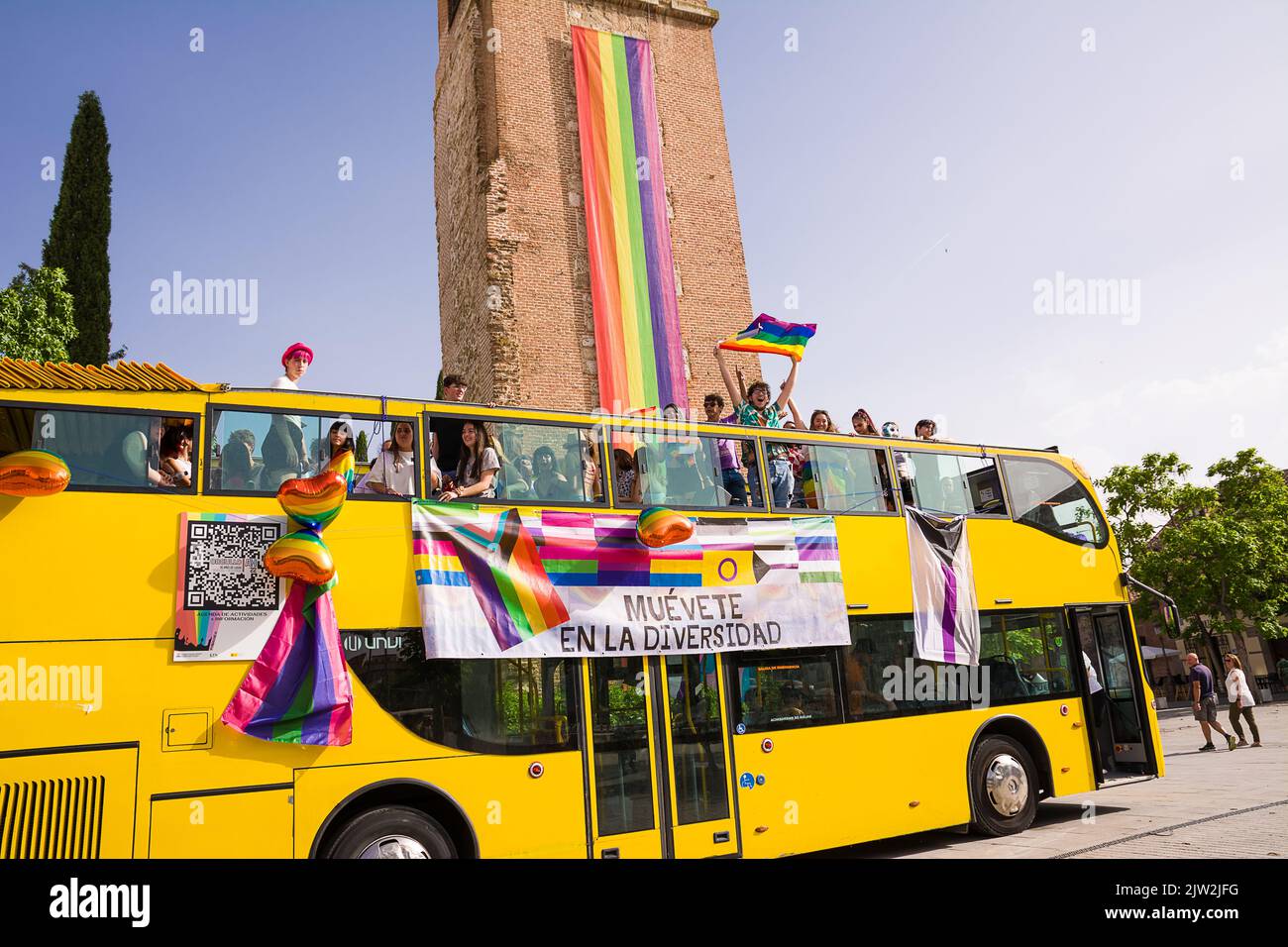 Alcalá de Henares, España - 18 de junio de 2022: Autobús abierto con manifestantes LGBTQ por el orgullo gay frente a la Torre de Santa María Foto de stock
