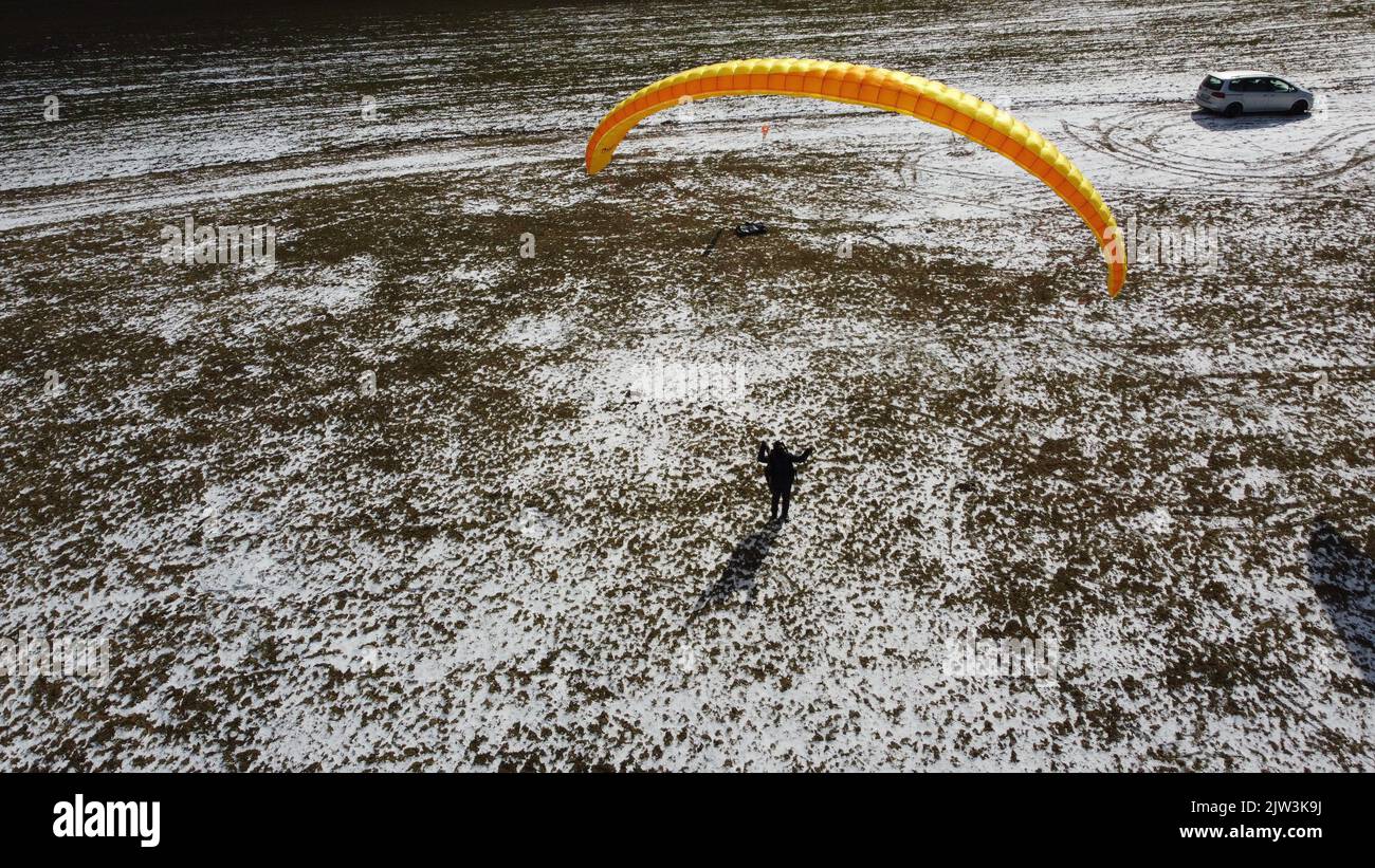 Vuelo en parapente y entrenamiento de manejo en tierra en el prado de Bykovice, república Checa, Unión Europea, vista panorámica aérea disparada con drone DJI-tiempo de invierno Foto de stock