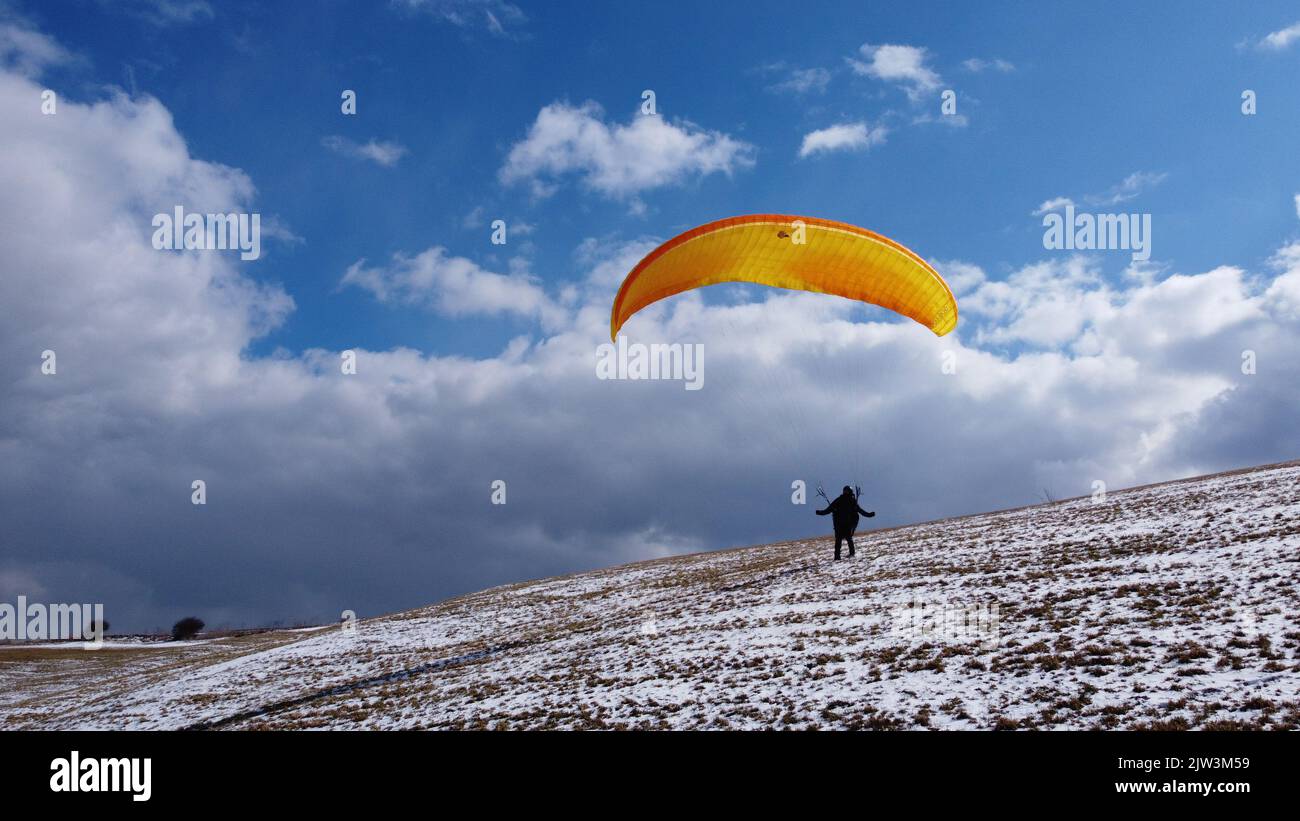 Vuelo en parapente y entrenamiento de manejo en tierra en el prado de Bykovice, república Checa, Unión Europea, vista panorámica aérea disparada con drone DJI-tiempo de invierno Foto de stock