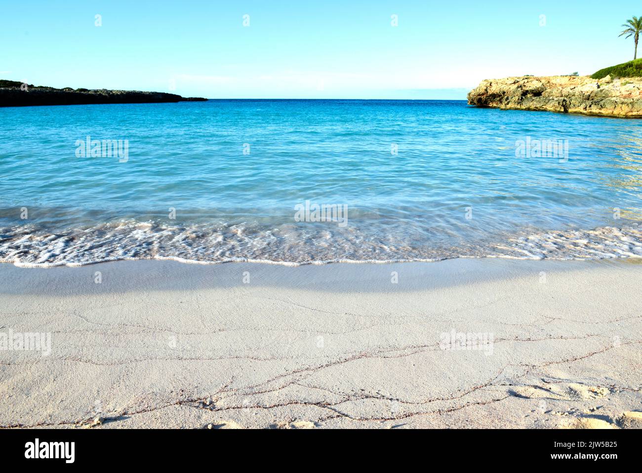 Hermosa playa vacía con arena blanca y agua azul clara del océano en la orilla Foto de stock