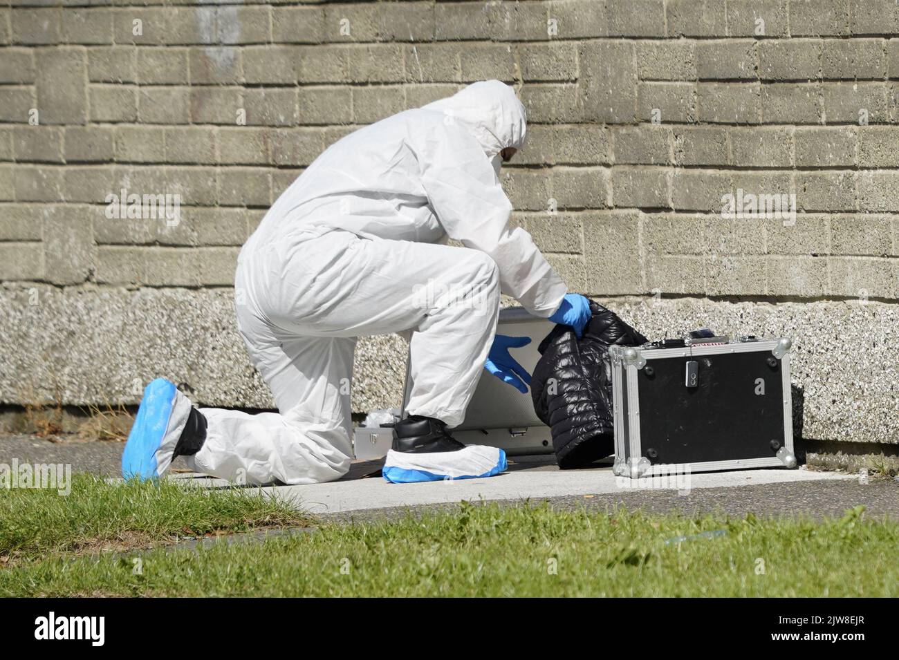 Los oficiales forenses sacan un abrigo de la escena en Rossfield Estate