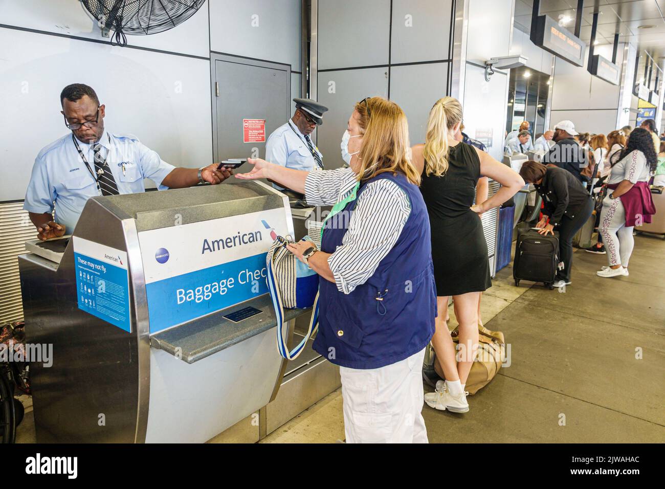 Miami Florida, Aeropuerto Internacional de Miami Terminal MIA, American Airlines Negro Skycap cheque de equipaje en la acera, hombre hombres mujer mujer mujer, EE.UU. EE.UU. ONU Foto de stock