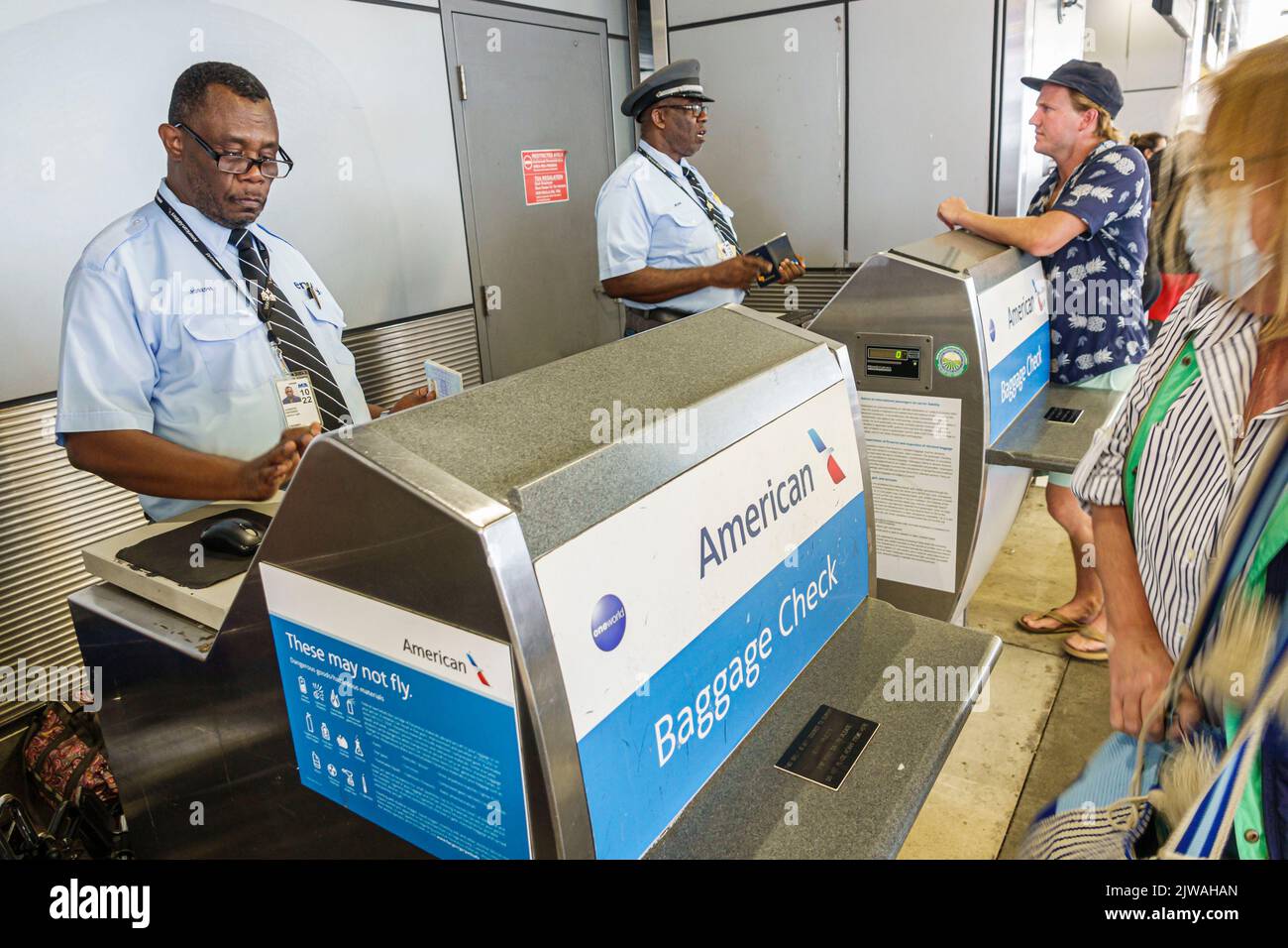Miami Florida, Aeropuerto Internacional de Miami Terminal MIA, American Airlines Negro Skycap cheque de equipaje en la acera, hombre hombres mujer mujer mujer, EE.UU. EE.UU. ONU Foto de stock