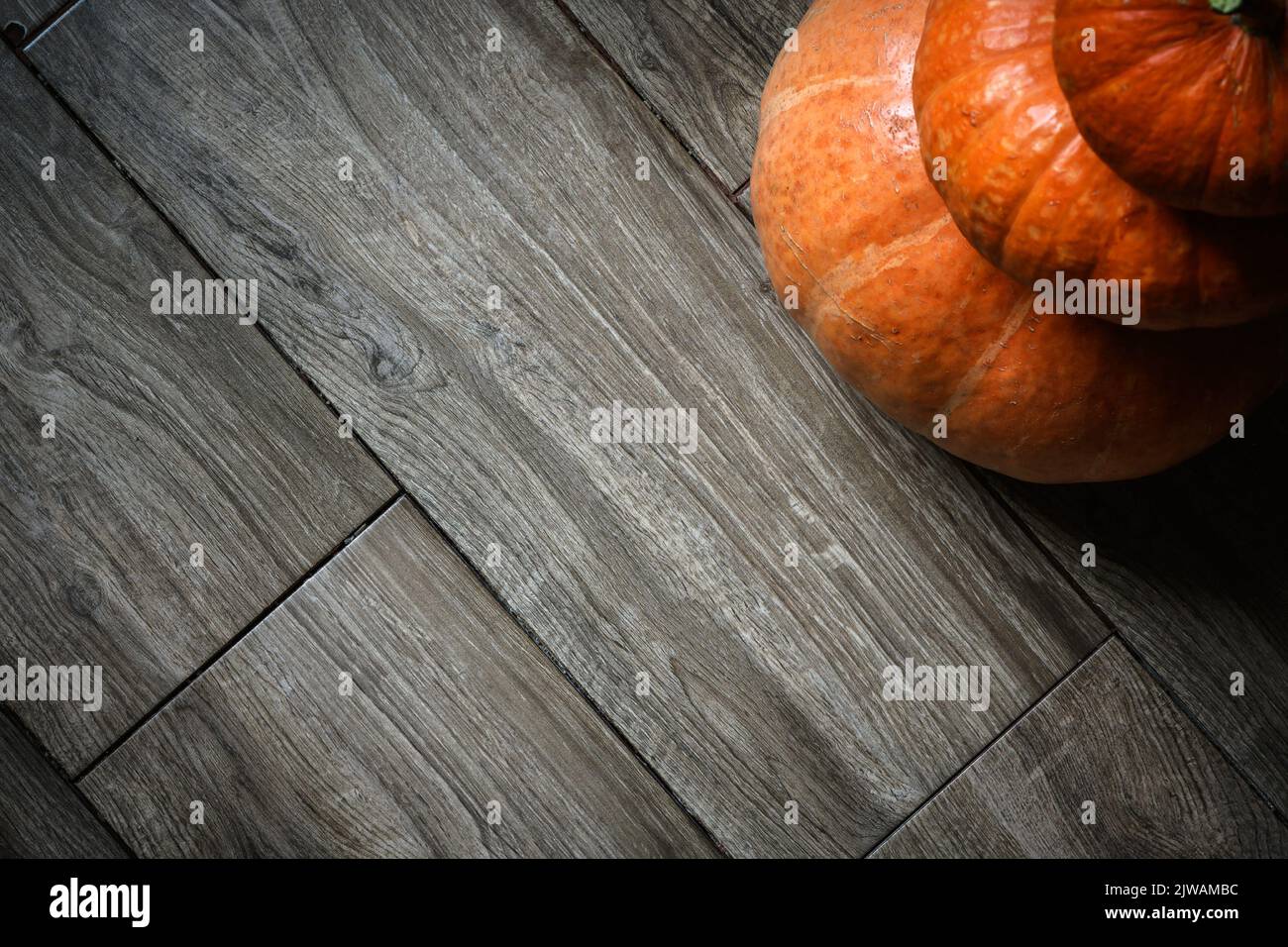 Pila de calabazas sobre tablones de madera de fondo para el tema de Halloween. Vista superior de la torre de verduras de color naranja en el suelo de madera y espacio. Halloween, gracias Foto de stock