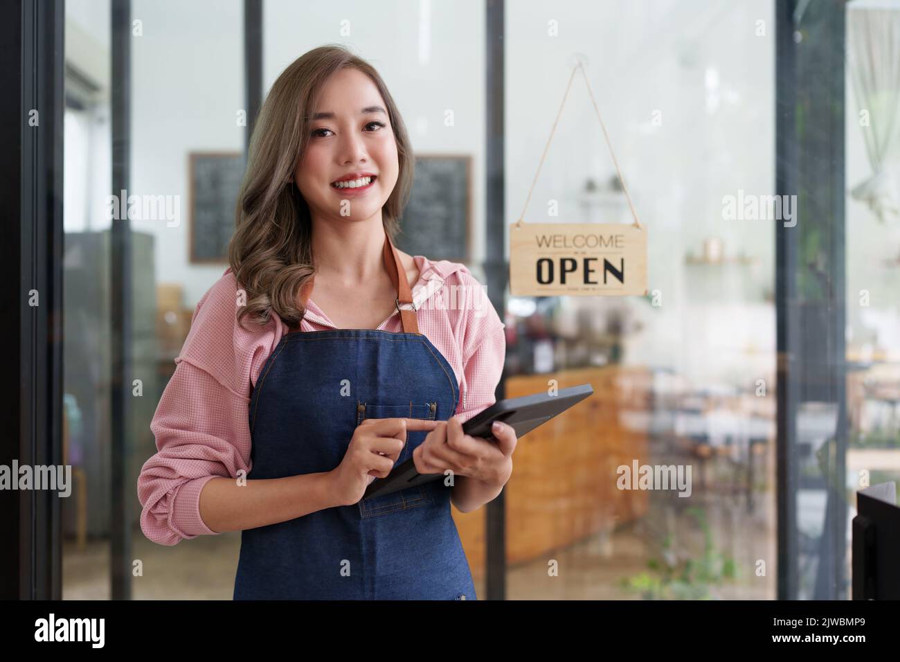 El propietario de la cafetería asiática Barista sonríe mientras la cafetería está abierta. Concepto de negocio de vendedor emprendedor de PYME Foto de stock