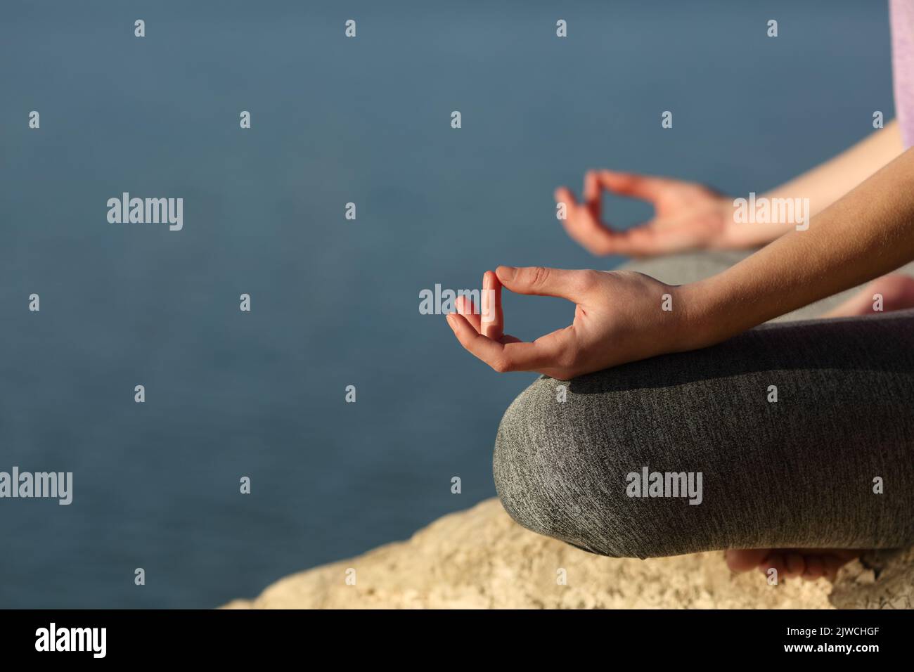 Clos eup de un yogui manos haciendo ejercicio de yoga en un lago Foto de stock