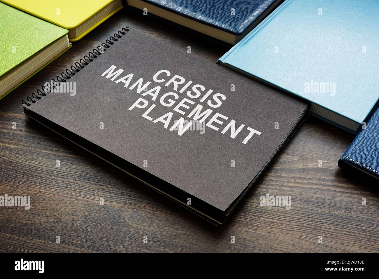 Plan de gestión de crisis y blocs de notas en el escritorio. Foto de stock
