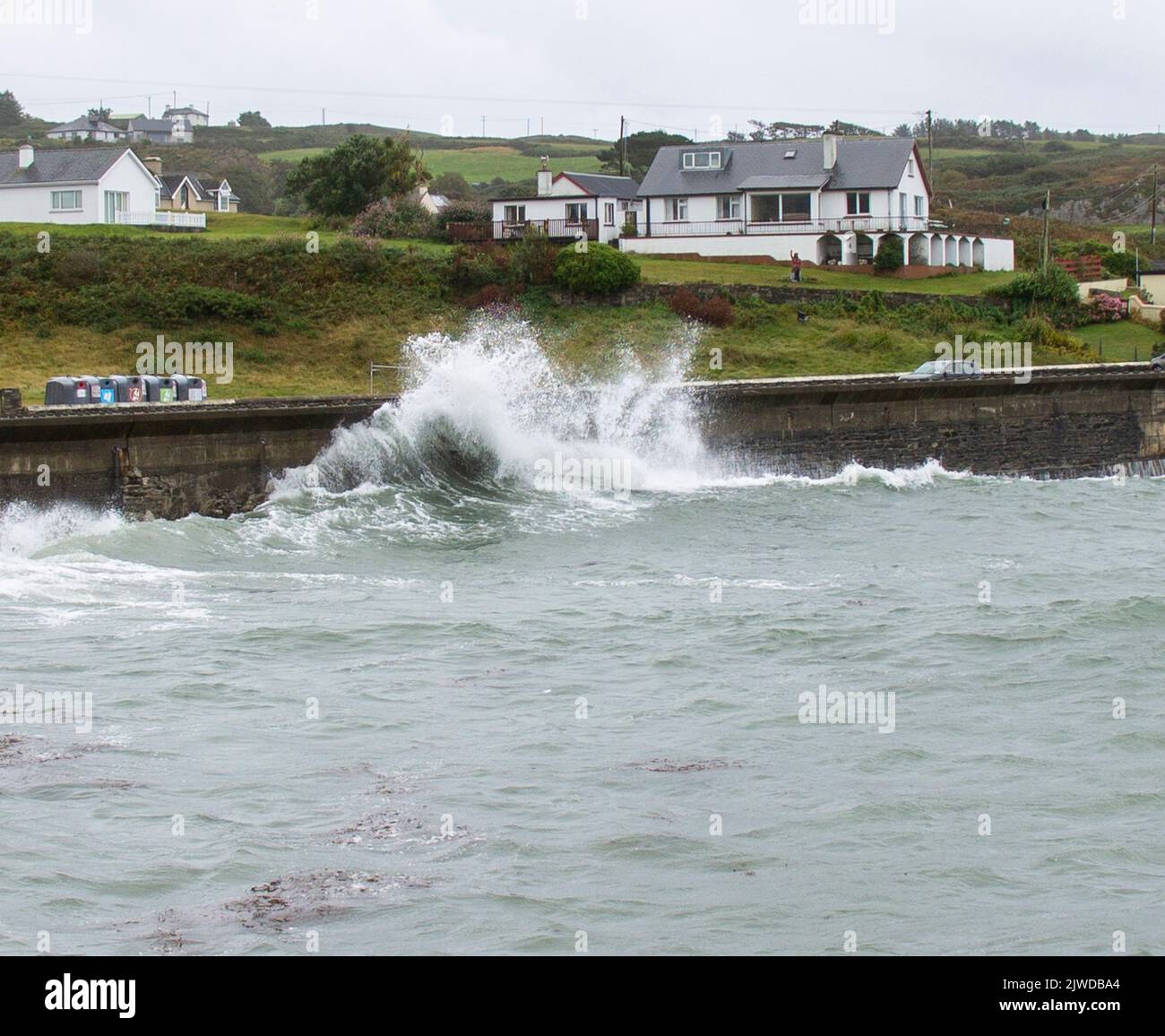 Olas otoñales rompiendo en el muro de defensa del mar, Tragumna, West Cork, Irlanda Foto de stock