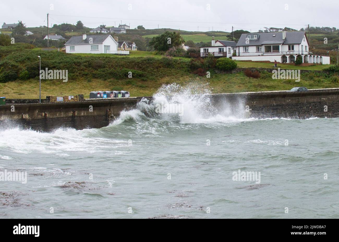Olas otoñales rompiendo en el muro de defensa del mar, Tragumna, West Cork, Irlanda Foto de stock
