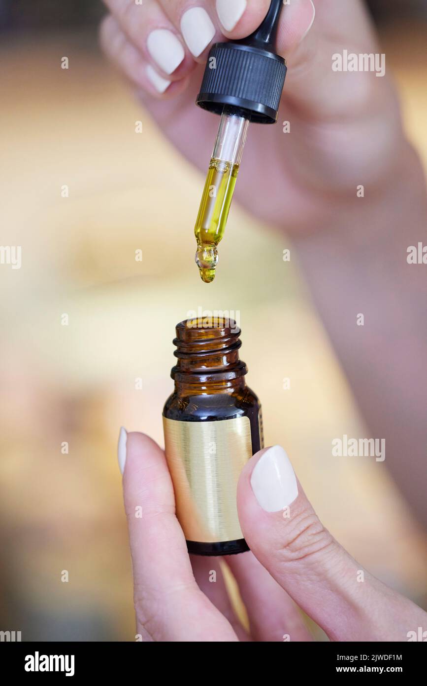 Primer plano de la mano con el aceite de cannabis medicinal CBD Foto de stock