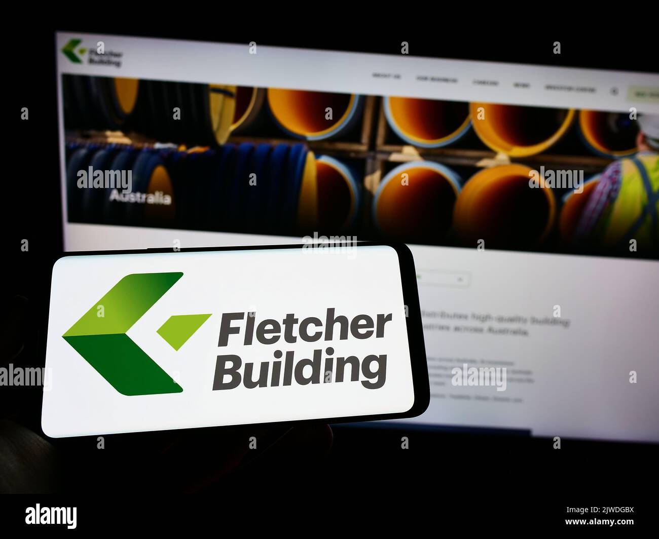 Persona que sostiene el teléfono celular con el logotipo de la empresa