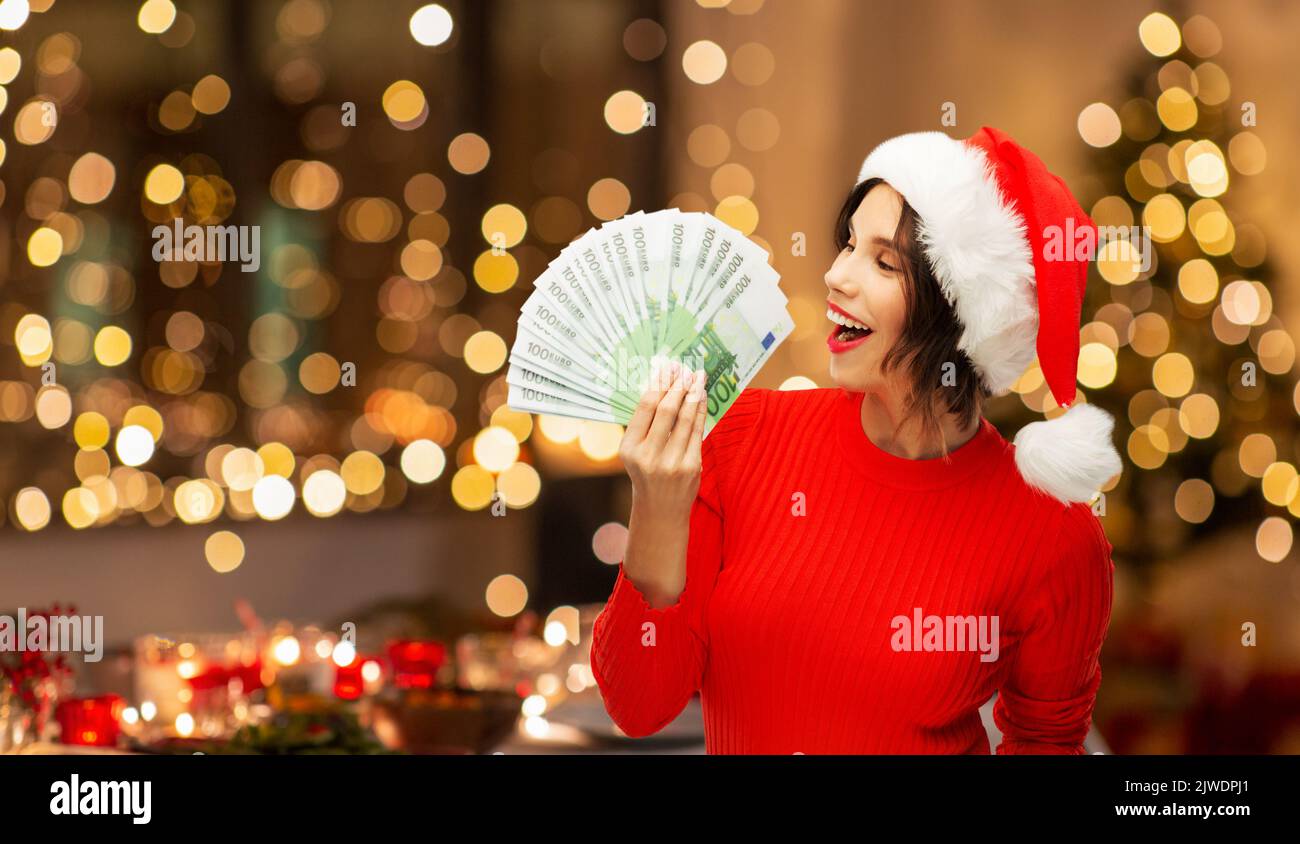 mujer feliz en sombrero de santa con dinero en navidad Foto de stock