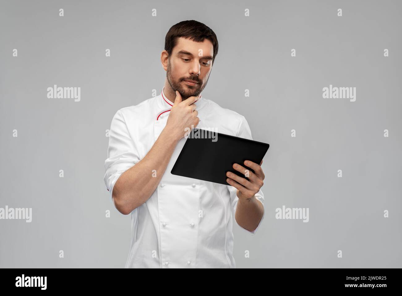 chef masculino pensamiento con tablet pc Foto de stock