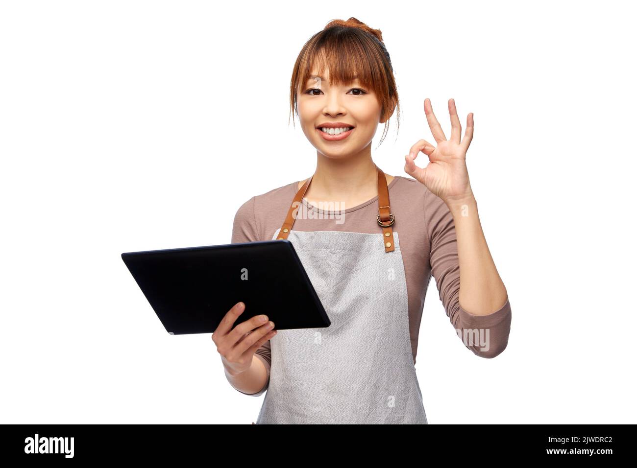 mujer feliz en delantal con la tableta pc mostrando ok Foto de stock