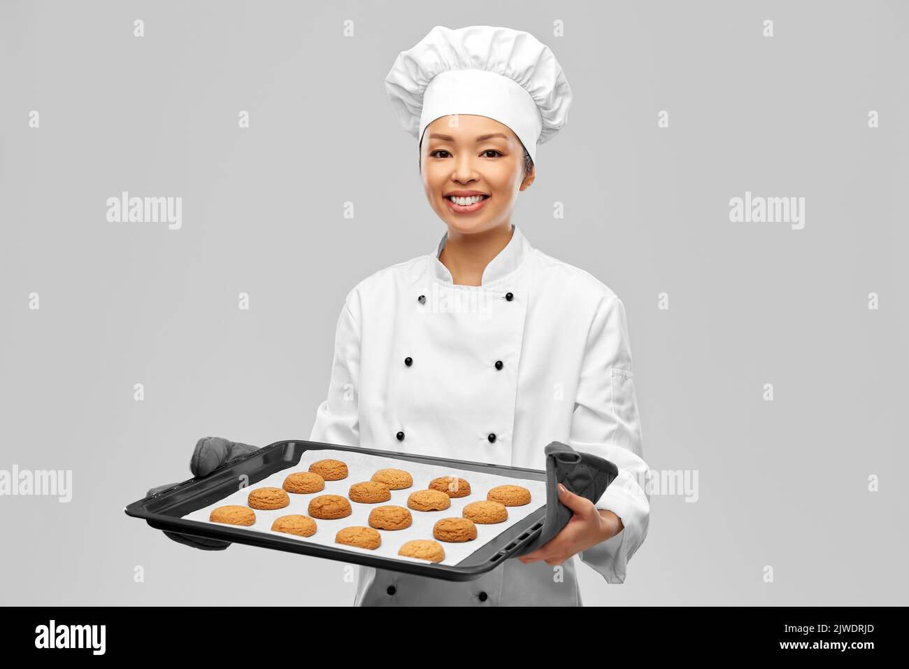 chef feliz con galletas en la bandeja del horno Foto de stock