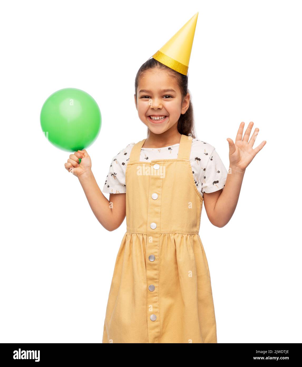 feliz niña en el cumpleaños fiesta sombrero soplando globo Foto de stock