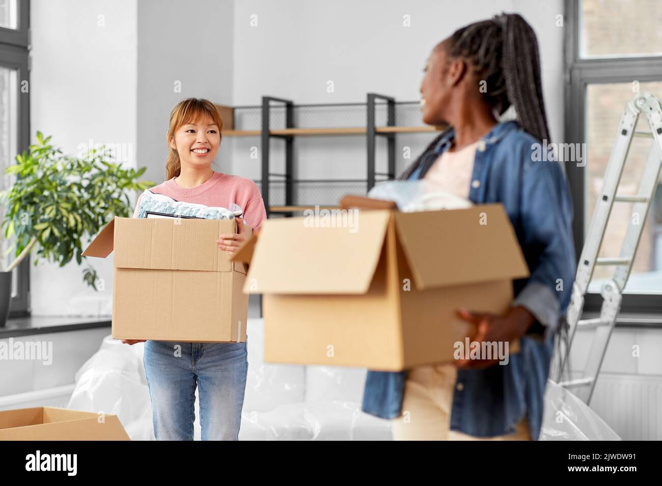 mujeres con cajas que se mudan a un nuevo hogar Foto de stock
