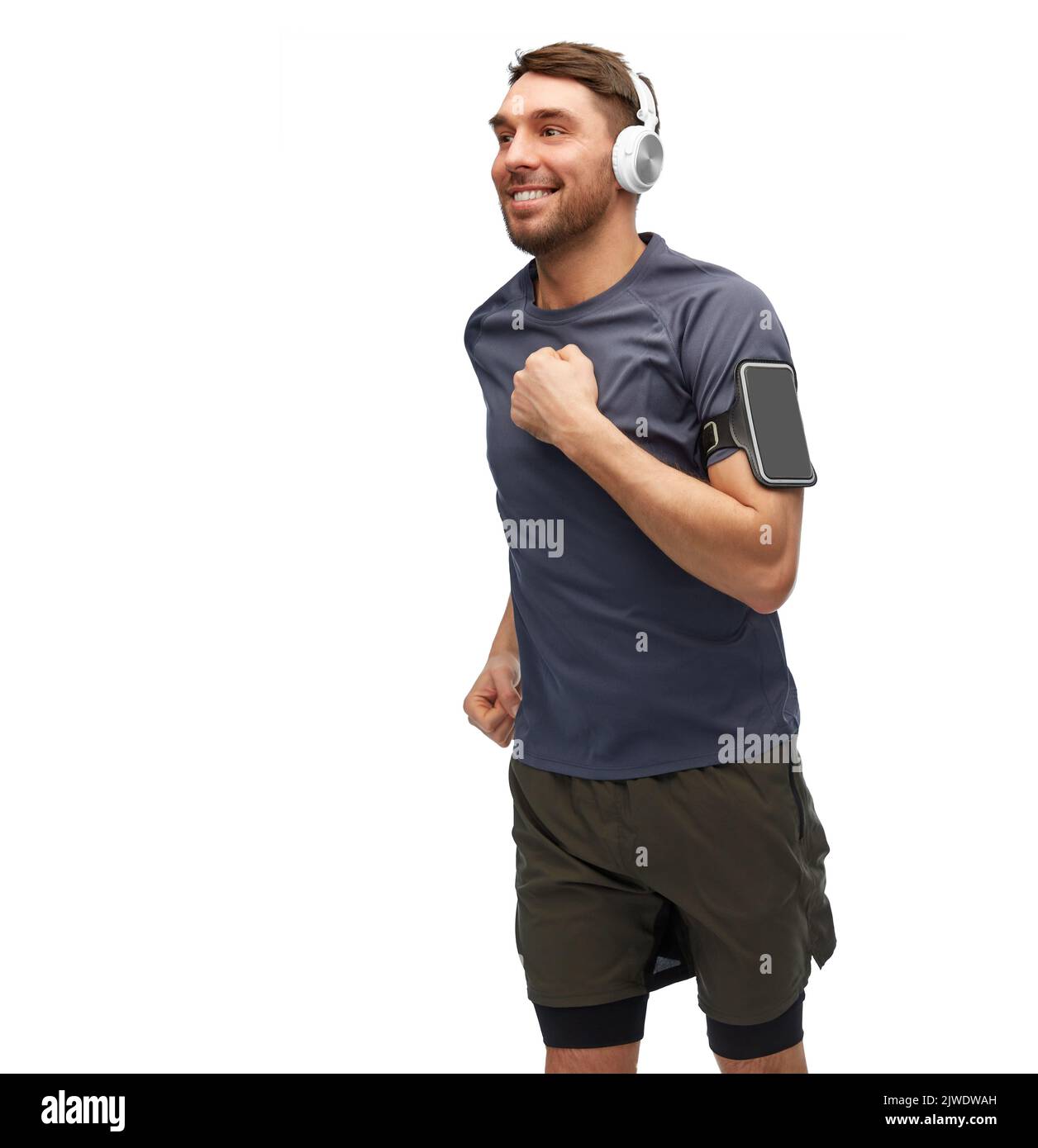 hombre sonriendo con auriculares con smartphone funcionando Foto de stock