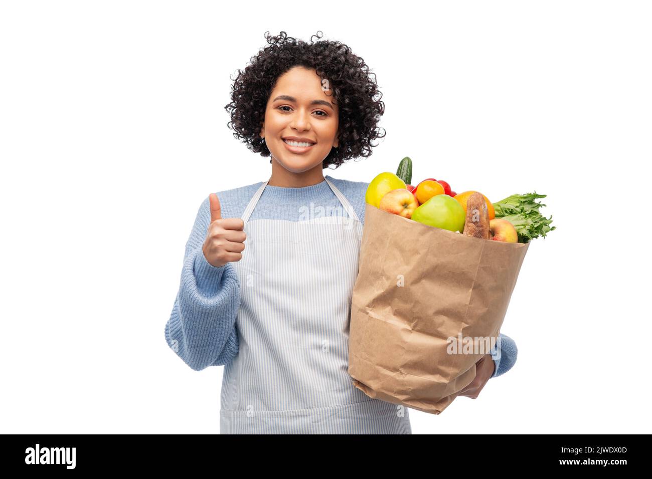 mujer en delantal con comida para llevar en bolsa de papel Foto de stock