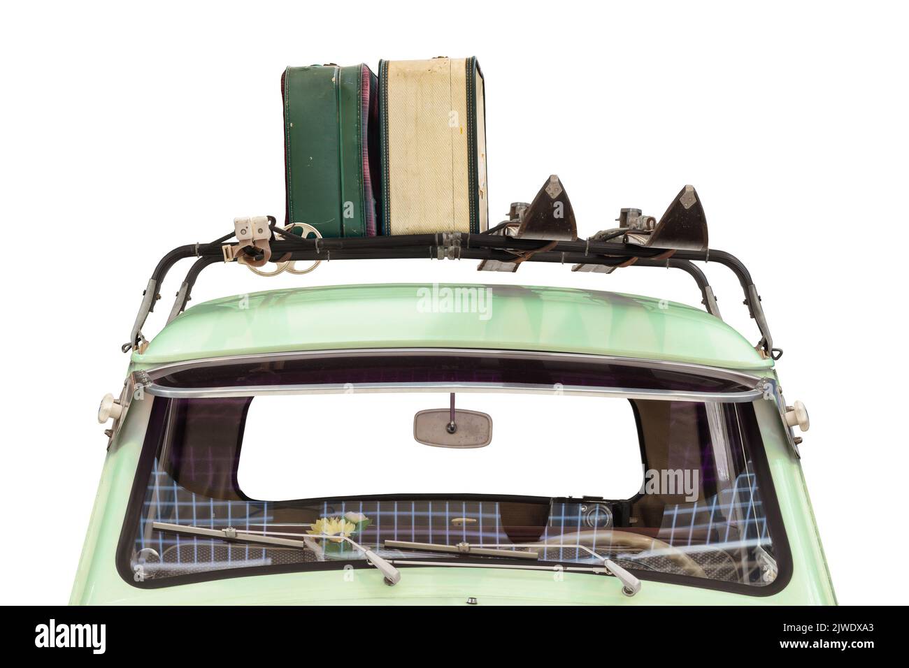 Vista frontal de un coche antiguo con esquís y equipaje adosado a una baca aislada sobre un fondo blanco Foto de stock