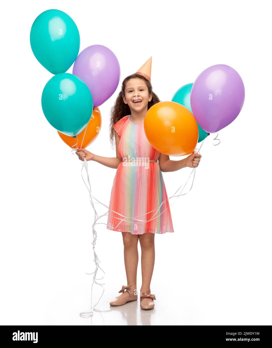 chica feliz en sombrero de fiesta de cumpleaños con globos Foto de stock