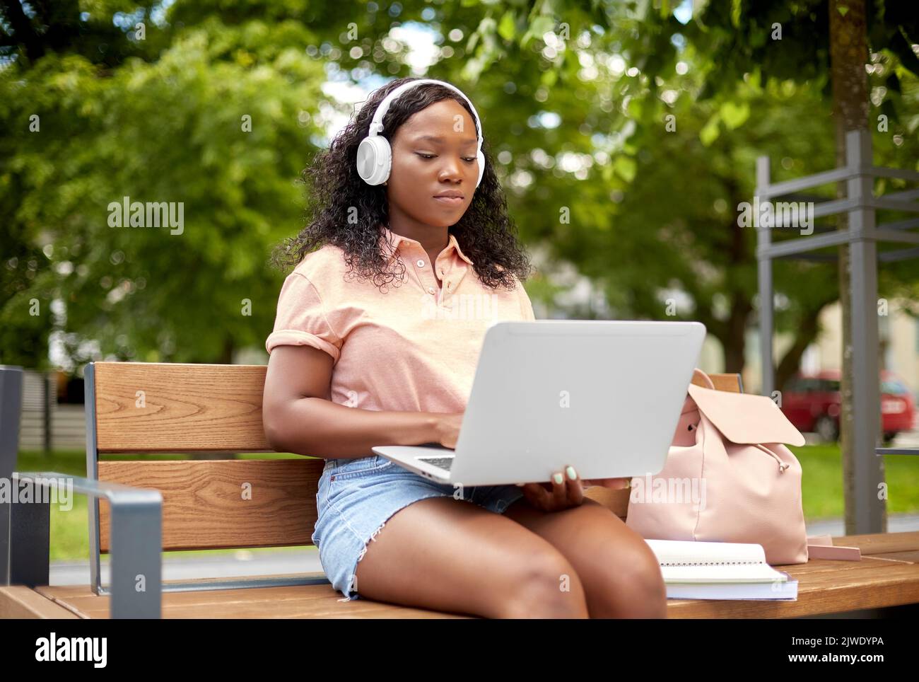 niña estudiante africana en auriculares con ordenador portátil Foto de stock