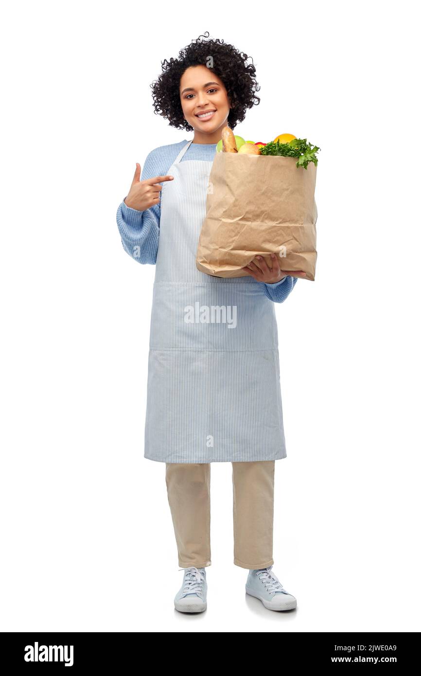mujer en delantal con comida para llevar en bolsa de papel Foto de stock