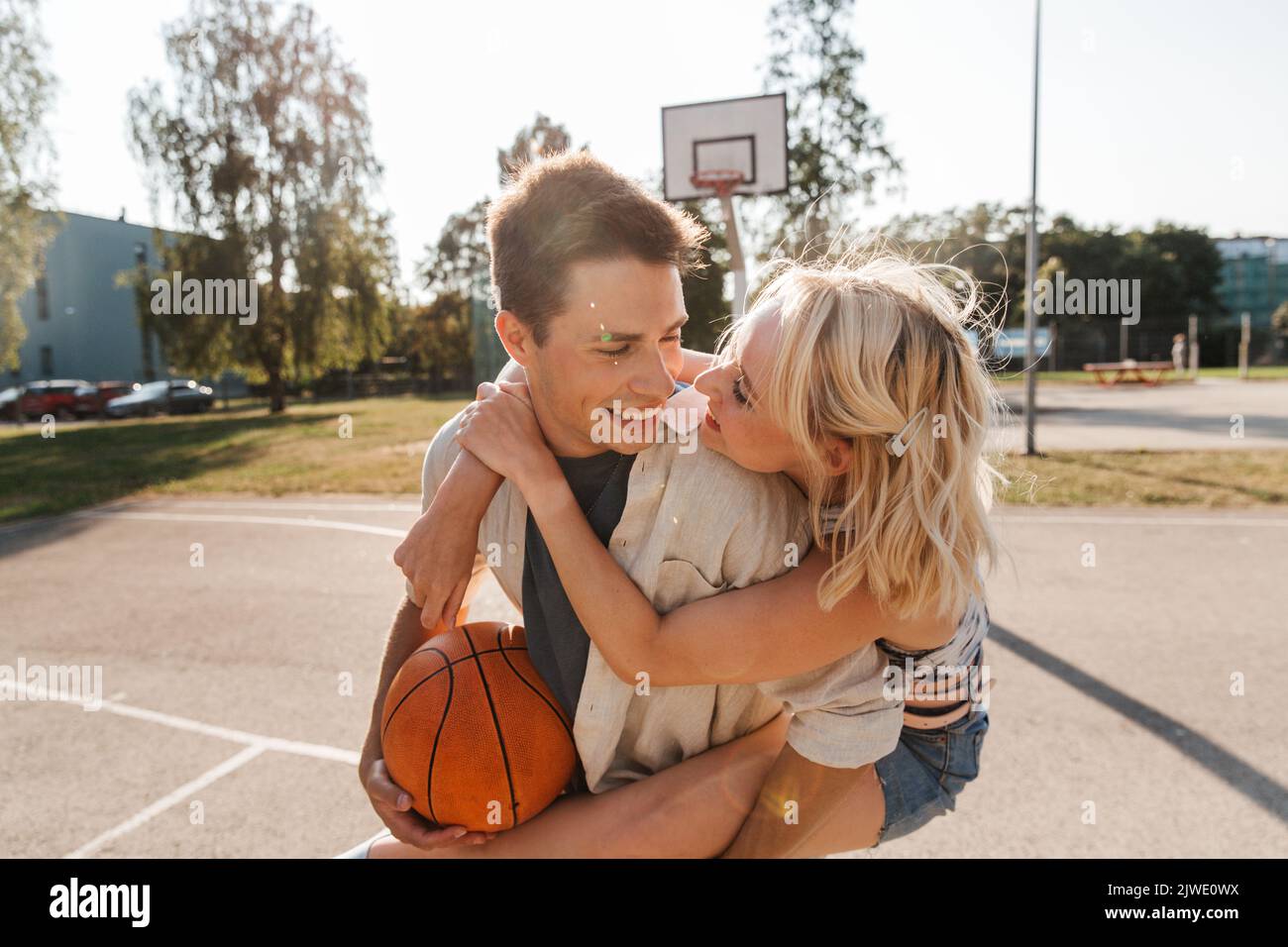 una pareja feliz se divierte en el patio de recreo de baloncesto Foto de stock